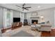 Inviting living room featuring a stone fireplace, ceiling fan and wood flooring at 831 Terrace Trce, Lawrenceville, GA 30044