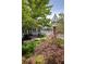 Beautifully landscaped backyard with vibrant plants, patio, and inviting birdhouse offers a tranquil outdoor space at 10559 Serenbe Ln, Chattahoochee Hills, GA 30268