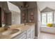 Stylish bathroom boasts a double vanity, a large mirror, and a window seat, offering both function and style at 10559 Serenbe Ln, Chattahoochee Hills, GA 30268
