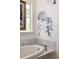 Modern bathroom featuring a soaking tub with marble accents and elegant floral wallpaper, creating a spa-like atmosphere at 10559 Serenbe Ln, Chattahoochee Hills, GA 30268