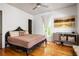 Bright bedroom features hardwood floors, a decorative bedframe, and abundant natural light, creating a cozy retreat at 10559 Serenbe Ln, Chattahoochee Hills, GA 30268