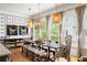 Bright dining room featuring unique lighting fixtures, modern art, and large windows with backyard views at 10559 Serenbe Ln, Chattahoochee Hills, GA 30268
