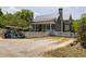 View of a charming house and a golf cart behind a white picket fence at 10559 Serenbe Ln, Chattahoochee Hills, GA 30268