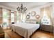 Bright main bedroom with hardwood floors, a chandelier, and large windows, creating an elegant and airy retreat at 10559 Serenbe Ln, Chattahoochee Hills, GA 30268