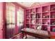 Pink office space with built-in shelves, French doors, and a trendy rug, creating a vibrant and inspiring workspace at 10559 Serenbe Ln, Chattahoochee Hills, GA 30268