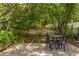 Small patio with black table and chairs surrounded by a well-landscaped yard at 10559 Serenbe Ln, Chattahoochee Hills, GA 30268