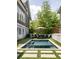 A backyard pool with an umbrella and seating, surrounded by well-manicured artificial grass at 10559 Serenbe Ln, Chattahoochee Hills, GA 30268