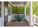 Inviting back porch with outdoor dining set, perfect for enjoying nature views and outdoor living at 10559 Serenbe Ln, Chattahoochee Hills, GA 30268