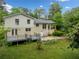 Back exterior of home featuring brick, deck, patio, and lush green yard at 1448 Drayton Woods Dr, Tucker, GA 30084