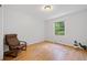 Bright bedroom with hardwood floors, a chair, and a large window overlooking trees at 1448 Drayton Woods Dr, Tucker, GA 30084