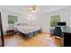 Light-filled bedroom with hardwood floors, ceiling fan, and built-in headboard at 1448 Drayton Woods Dr, Tucker, GA 30084