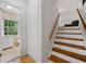 Hallway view with access to bathroom, stairs with wood-stained steps and white risers at 1448 Drayton Woods Dr, Tucker, GA 30084