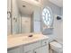 Bathroom with a white vanity, an oval window, and a large mirror at 1259 Crescentwood Ln, Decatur, GA 30032