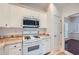 Eat-in kitchen shows stainless microwave, white cabinetry, white gas range and tile countertops at 1259 Crescentwood Ln, Decatur, GA 30032
