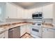 Well-lit kitchen featuring white cabinetry, stone countertops, and modern appliances at 1259 Crescentwood Ln, Decatur, GA 30032