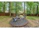Backyard features a fire pit area with seating, surrounded by lush trees and a wooden fence, perfect for outdoor gatherings at 150 Shady Grove Ln, Alpharetta, GA 30009