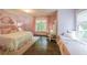 Light-filled bedroom with pink walls, hardwood floors, a window seat, and matching curtains for a charming, cohesive look at 150 Shady Grove Ln, Alpharetta, GA 30009