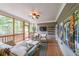 Relaxing screened-in porch featuring comfortable seating, wood floors, and a ceiling fan, ideal for outdoor living at 150 Shady Grove Ln, Alpharetta, GA 30009