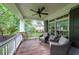 Relaxing covered porch with comfortable seating, ceiling fan, and wooded views at 150 Shady Grove Ln, Alpharetta, GA 30009
