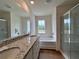 A well lit bathroom with double sinks, granite countertop, and glass enclosed shower at 1956 Asher Ln # 51, Conyers, GA 30013