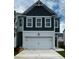 Charming two-story home featuring a two-car garage and a modern, dark-green paneled facade at 1956 Asher Ln # 51, Conyers, GA 30013