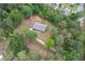 Aerial view of a brick house surrounded by lush green trees in a wooded area at 3881 Moore Rd, Ellenwood, GA 30294