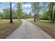 Long concrete driveway leading to the charming home surrounded by mature trees at 3881 Moore Rd, Ellenwood, GA 30294