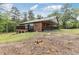 The back exterior of the house has a covered deck with a wooded view at 3881 Moore Rd, Ellenwood, GA 30294