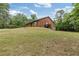 Charming brick home on a grassy hill with mature trees in the background at 3881 Moore Rd, Ellenwood, GA 30294