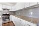 Close up of granite countertops, stainless steel oven and grey tile backsplash at 3881 Moore Rd, Ellenwood, GA 30294