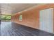 Covered porch with access to the home's entrance with an exterior view of the wooded yard at 3881 Moore Rd, Ellenwood, GA 30294