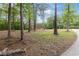 The house in seen in the distance as it sits on a large lot surrounded by mature trees at 3881 Moore Rd, Ellenwood, GA 30294