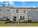 Backyard showing two-story townhomes with patios, green lawns, and partial fence at 7246 Alicias Way, Morrow, GA 30260