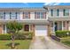 Traditional townhouse with a one-car garage, well-manicured lawn, and shrubbery at 7246 Alicias Way, Morrow, GA 30260