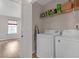Laundry room with washer, dryer, and overhead shelving with a view into a bedroom at 7246 Alicias Way, Morrow, GA 30260