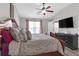 Spacious main bedroom with a ceiling fan, plush bed set, and a door to the en suite at 7246 Alicias Way, Morrow, GA 30260