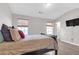 The main bedroom features wood floors, two windows, a tv and a comfortable bed at 7246 Alicias Way, Morrow, GA 30260