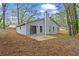 Backyard showing gray siding, patio, and mature trees providing shade at 1360 Terramount Dr, Roswell, GA 30076
