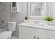 Bathroom with white cabinets, sink, toilet, and a marble tiled wall at 1360 Terramount Dr, Roswell, GA 30076