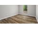 An empty bedroom featuring a window, wood floors, and modern gray walls at 1360 Terramount Dr, Roswell, GA 30076