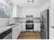 Modern kitchen featuring stainless steel appliances, granite countertops, and white cabinetry at 1360 Terramount Dr, Roswell, GA 30076