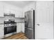 Bright kitchen featuring stainless steel appliances, white cabinets, and wood-look flooring at 1360 Terramount Dr, Roswell, GA 30076