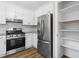 Bright kitchen featuring stainless steel appliances, white cabinets, and wood-look flooring at 1360 Terramount Dr, Roswell, GA 30076