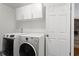 A clean laundry room features new washer and dryer, white walls and cabinets at 1360 Terramount Dr, Roswell, GA 30076