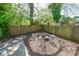 Cozy fenced backyard with a charming fire pit and seating area under the shade of mature trees at 224 Bass Sw St, Atlanta, GA 30315