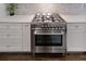 Close-up of the kitchen stove with stainless steel finish, white cabinets, and granite countertops at 224 Bass Sw St, Atlanta, GA 30315