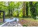 A lush backyard with a stone patio surrounded by tall trees, offering shade and tranquility at 1959 Oana Sw St, Atlanta, GA 30310