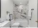 Bathroom with marble-like tile, soaking tub, and gold fixtures at 1959 Oana Sw St, Atlanta, GA 30310