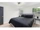 Bedroom with modern ceiling fan, natural light, light wood floors, black door and comfortable bed at 1959 Oana Sw St, Atlanta, GA 30310