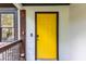 Close-up of a bright yellow front door with sleek, modern hardware and a secure keyless entry system at 1959 Oana Sw St, Atlanta, GA 30310